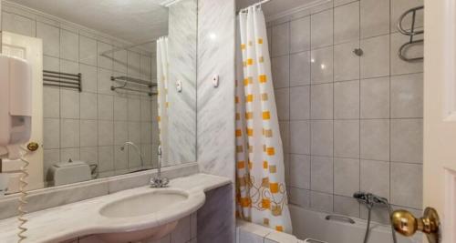 a bathroom with a sink and a shower at Rigas Hotel Skopelos in Skopelos Town