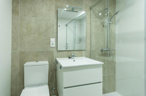 y baño con aseo, lavabo y ducha. en LETS HOLIDAYS Beachfront apartment tossa de mar en Tossa de Mar