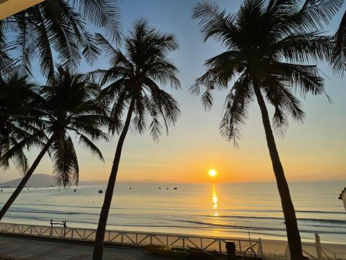a sunset on the beach with palm trees at Paradise Resort Doc Let - All Inclusive in Doc Let