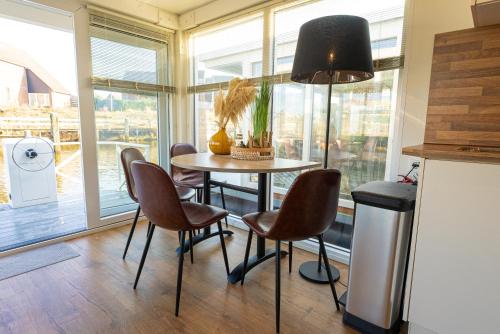 a kitchen with a table and chairs in front of a window at Houseboats Lemmer in Lemmer