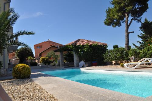 a swimming pool in front of a house at Apartments Villa Lora in Kraj