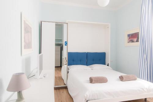 uma cama branca com uma cabeceira azul num quarto em Taaac Apartment - The House Of Travelers em Como