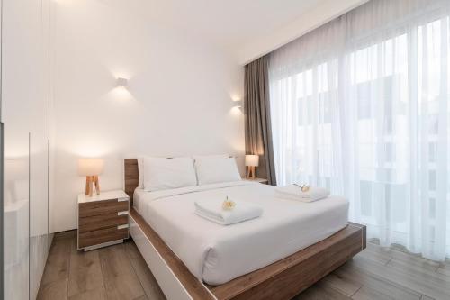 a bedroom with a large white bed with two towels on it at Purple Haze By AirCasa in Nairobi