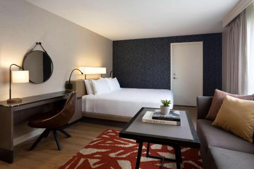 um quarto de hotel com uma cama, um sofá e uma mesa em Hyatt Regency San Antonio Riverwalk em San Antonio