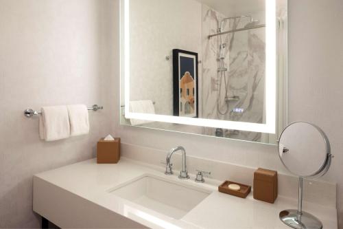 a white bathroom with a sink and a mirror at Hyatt Regency San Antonio Riverwalk in San Antonio