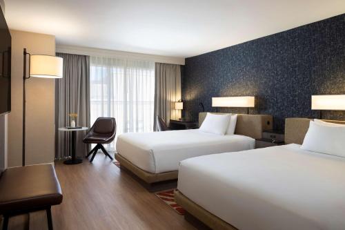 a hotel room with two beds and a desk at Hyatt Regency San Antonio Riverwalk in San Antonio
