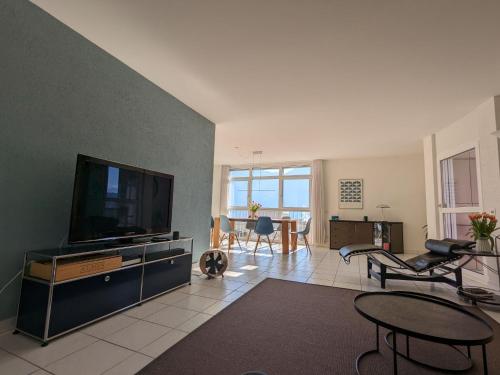 Apartment Residenza Canto Sereno by Interhome في Minusio: غرفة معيشة مع تلفزيون بشاشة مسطحة وطاولة