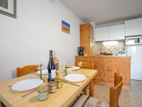 - une cuisine avec une table en bois et une bouteille de vin dans l'établissement Apartment Los Amigos-4 by Interhome, au Grau-du-Roi