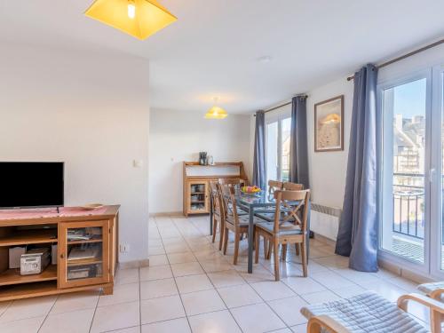 une salle à manger avec une table, des chaises et une télévision dans l'établissement Apartment Les Marines 1 et 2-4 by Interhome, à Cabourg