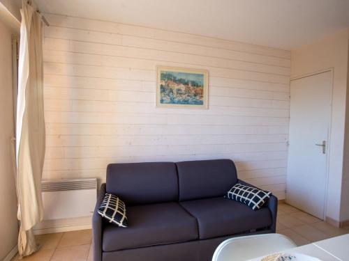 niebieską kanapę w pokoju ze ścianą w obiekcie Studio Les Rives de la Favière-14 by Interhome w mieście La Favière