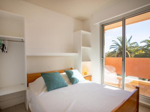 une chambre avec un lit et une grande fenêtre dans l'établissement Apartment Les Rives de la Favière-5 by Interhome, à La Favière