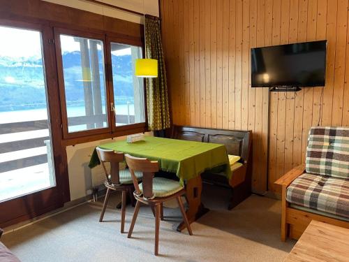ein Esszimmer mit einem grünen Tisch und Stühlen in der Unterkunft Apartment Platten by Interhome in Gersau