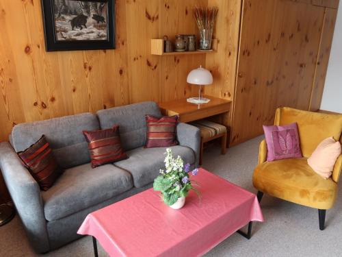 een woonkamer met een bank, 2 stoelen en een tafel bij Apartment Utoring Acletta-25 by Interhome in Disentis