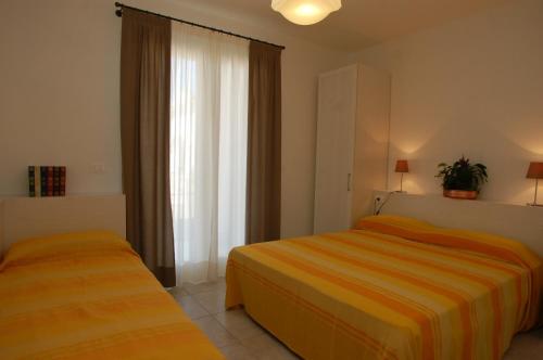 Habitación de hotel con 2 camas y ventana en Comfy apartment in a quiet area en Bibione