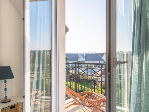 een kamer met een balkon met uitzicht op een gebouw bij Apartment Les Marines 1 et 2-7 by Interhome in Cabourg