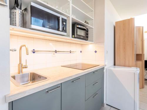 a kitchen with white cabinets and a sink at Apartment Les Marines 1 et 2-7 by Interhome in Cabourg