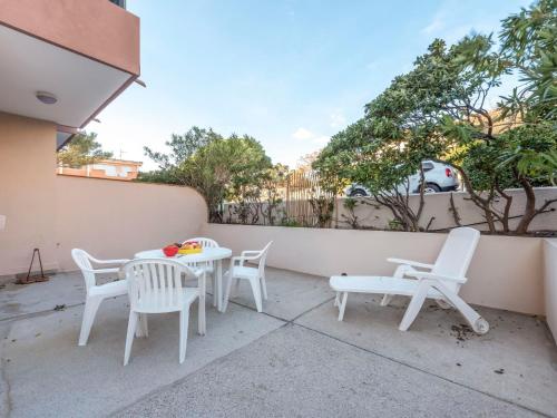 d'une terrasse avec des chaises blanches et une table. dans l'établissement Studio Antares-1 by Interhome, à Cavalaire-sur-Mer