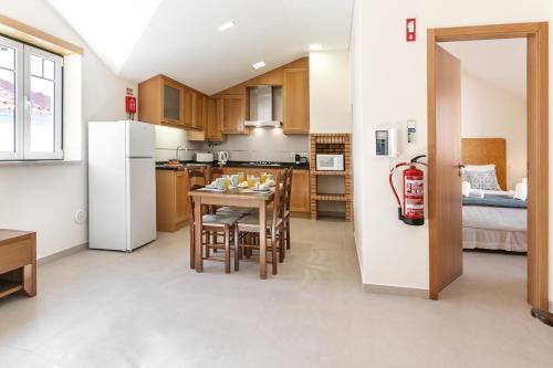 uma cozinha e sala de jantar com uma mesa e um frigorífico em Nazaré Boutique Apartment II na Nazaré