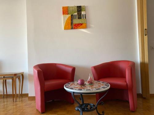 two red chairs and a table in a room at Apartment App- Paradiso by Interhome in Paradiso