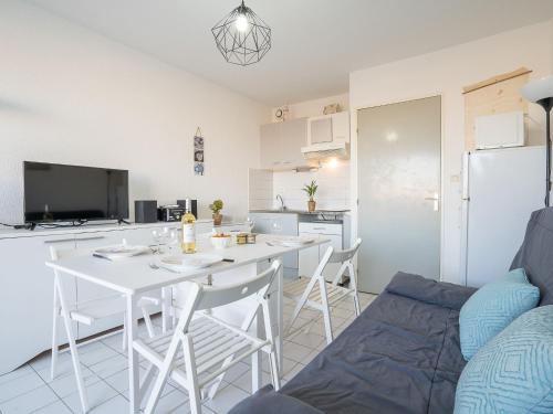 une cuisine et un salon avec une table et des chaises blanches dans l'établissement Studio Voiles d'Or-Gênois-3 by Interhome, au Grau-du-Roi