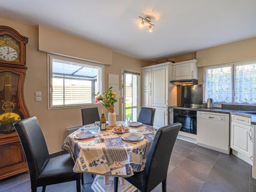 une salle à manger avec une table, des chaises et une horloge dans l'établissement Holiday Home Zal by Interhome, à Saint-Pierre-Quiberon