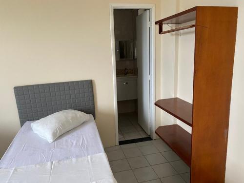 Dormitorio pequeño con cama y armario en Hotel Sirena, en Praia Grande