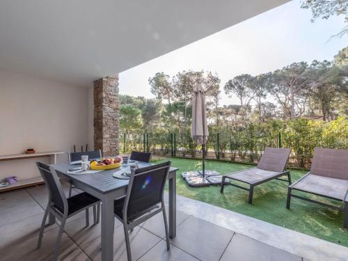 a dining room with a table and chairs and a garden at Apartment Le Domaine-1 by Interhome in Cavalaire-sur-Mer