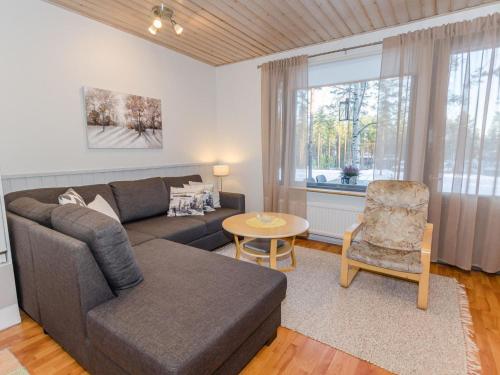a living room with a couch and a table at Holiday Home Loma-koli 3 by Interhome in Hattusaari