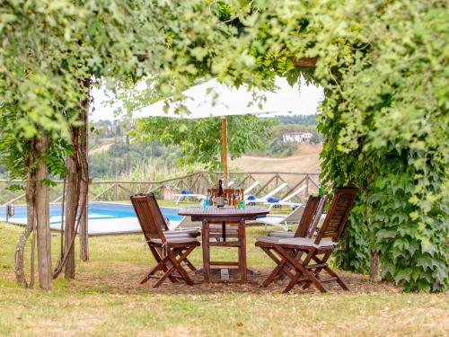 ein Picknicktisch und Stühle unter einem Schirm in der Unterkunft Villa Ghizzano by Interhome in Peccioli