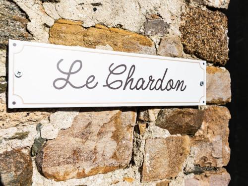 un panneau sur un mur de pierre avec le mot le chandon dans l'établissement Holiday Home Les Chardons by Interhome, à Pirou
