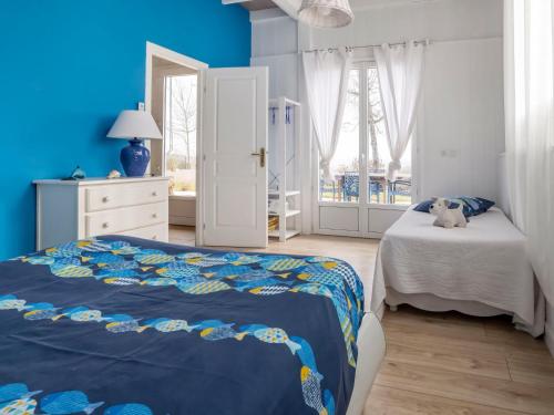 une chambre avec un lit et un mur bleu dans l'établissement Holiday Home L'Orme by Interhome, à Loupiac