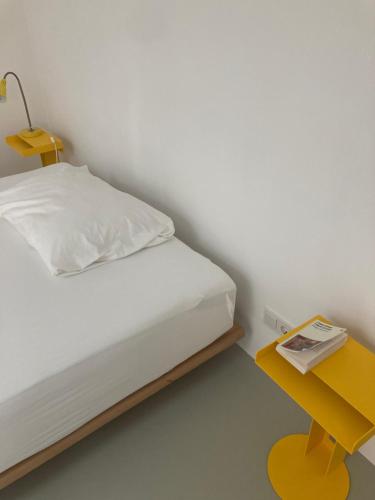 a bedroom with a bed and a yellow table at Bretzenstudios in Hall in Tirol
