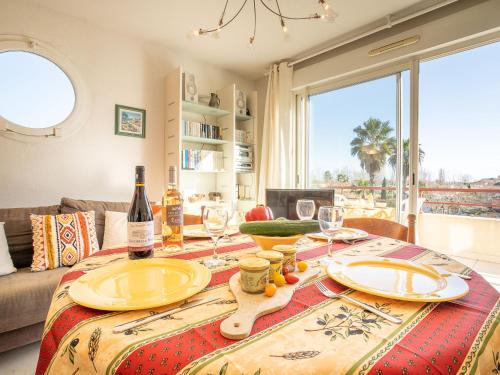 - une table à manger avec des bouteilles de vin et des verres dans l'établissement Apartment L'Hyppocampe by Interhome, au Grau-du-Roi