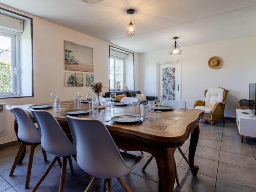 a dining room with a large wooden table and chairs at Holiday Home Le Coquelicot by Interhome in Pirou