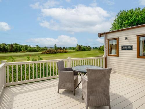 a patio with a table and chairs on a deck at Holiday Home Golf View by Interhome in Nairn