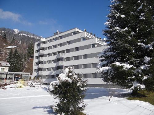 ein großes Apartmenthaus mit Schnee davor in der Unterkunft Apartment Sunnmatt 128 by Interhome in Engelberg