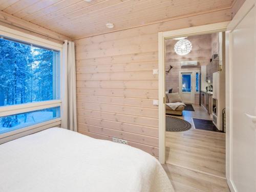 a bedroom with wooden walls and a large window at Holiday Home Halla by Interhome in Sirkka