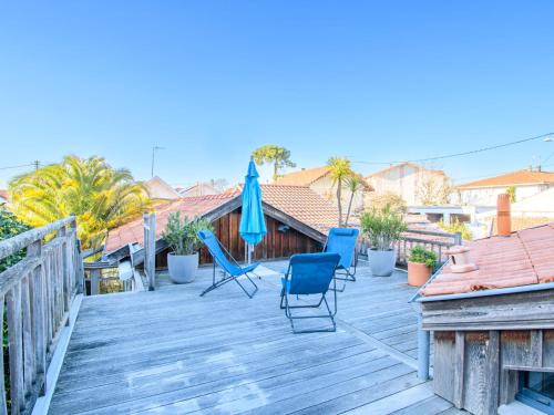 - une terrasse avec des chaises et un parasol dans l'établissement Holiday Home La Belle Tendel by Interhome, à Arcachon