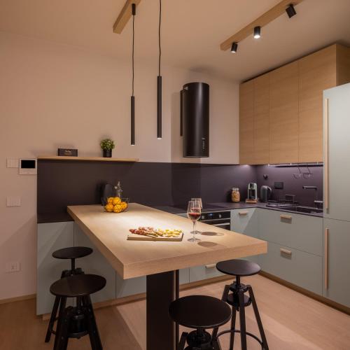 a kitchen with a wooden island with bar stools at Appartamento AmaRèmin - Vivere Rimini in Rimini