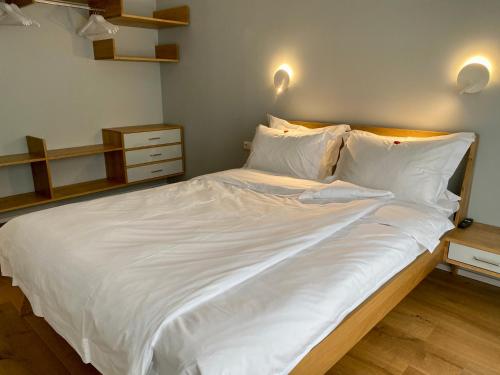 a large bed with white sheets and pillows at The Layhead B&B in Lübeck