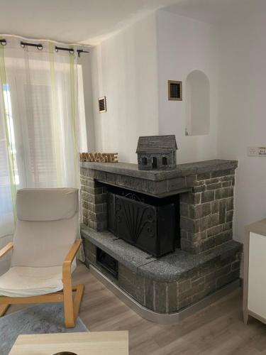 a living room with a brick fireplace and a chair at Casa Rosina - Una caramella, nel nucleo, ai piedi della Verzasca- in Gordola