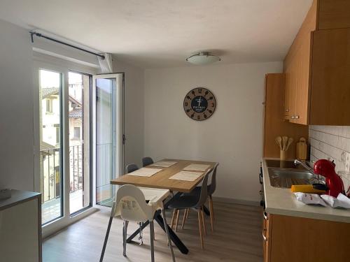 uma cozinha com uma mesa de madeira e cadeiras num quarto em Casa Rosina - Una caramella, nel nucleo, ai piedi della Verzasca- em Gordola
