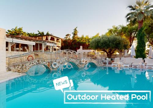 a pool at a hotel with a sign that reads outdoor heated pool at Acrotel Athena Pallas in Elia