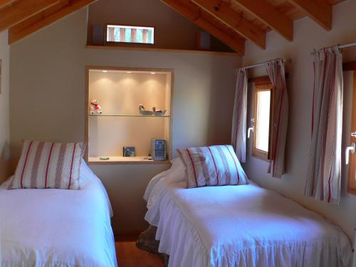 een slaapkamer met 2 bedden met witte lakens en een raam bij Casa"La Gomera" in Los Silos
