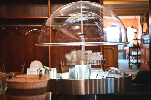 a restaurant counter with a glass dome and glasses at Berghotel Steiger - Erzgebirge in Schneeberg