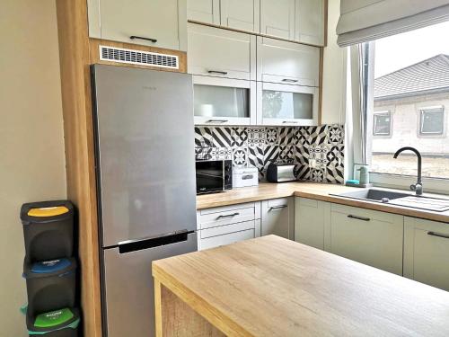 a kitchen with a stainless steel refrigerator and a table at Boya Home in Wilkasy