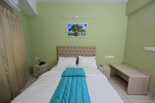 ein Schlafzimmer mit 2 Betten und einer Bank darin in der Unterkunft RG's The 4th Residency in Thiruvananthapuram