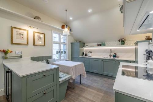 a kitchen with green cabinets and a white counter top at Stylish 2 Bed/2 Bath Flat In The Heart Of Windsor in Windsor