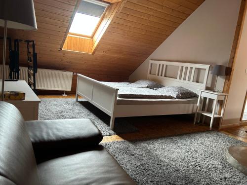 a bedroom with a bed in a attic with a window at Pension Zum Paradies in Harthausen