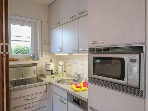 a kitchen with a sink and a microwave at Ferienwohnung Emilia, FeWo Vermittlung Nordsee in Dangast